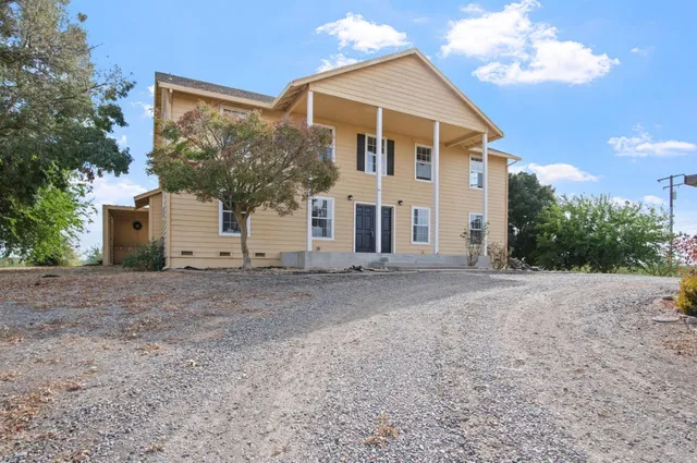 a view of a white house with a yard and garage
