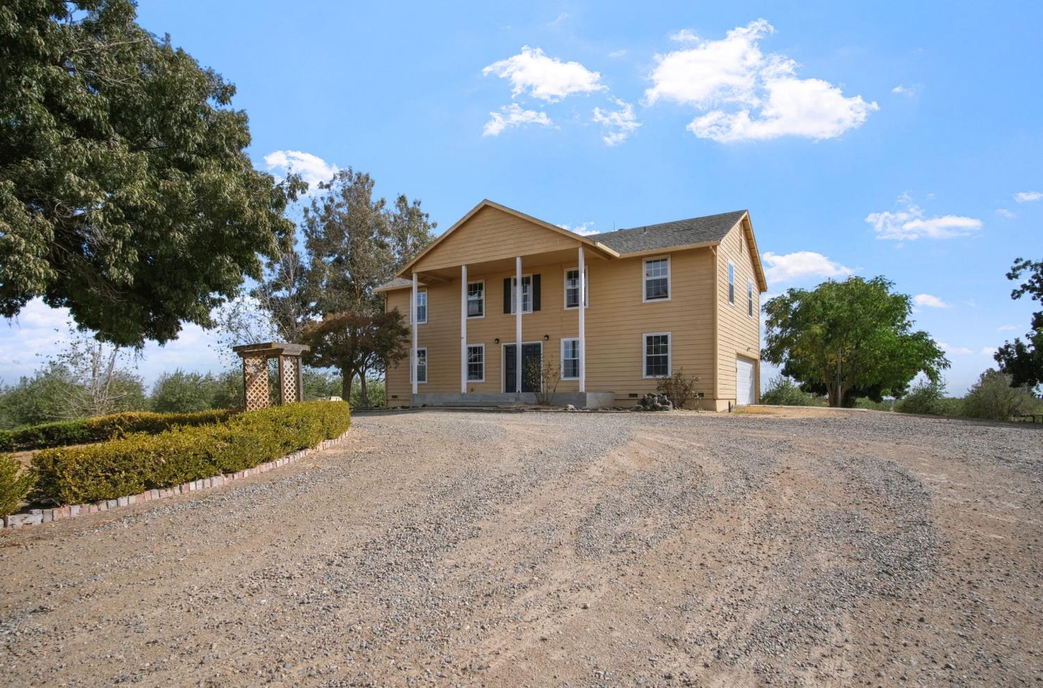 18624 Lake Road Hickman, CA 95323 - Photo 5 of 34 a front view of a house with a yard and garage