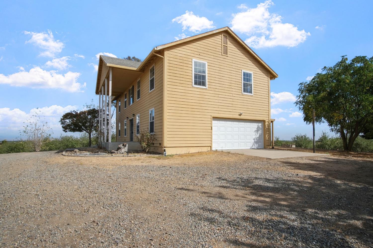 18624 Lake Road Hickman, CA 95323 - Photo 8 of 34 a front view of a house with a yard and garage