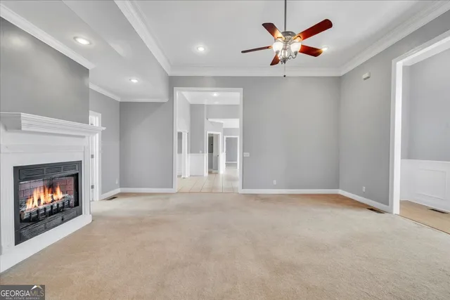 a view of an empty room with a window and chandelier fan