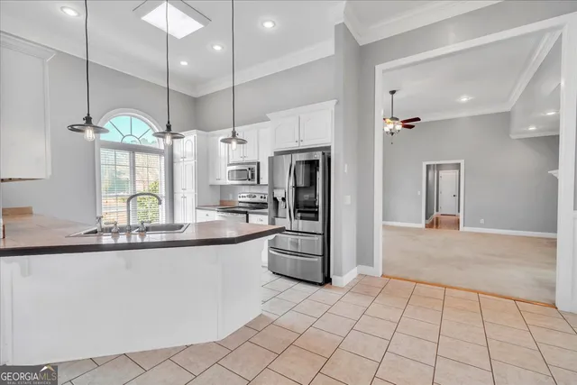an empty room with windows and a chandelier fan