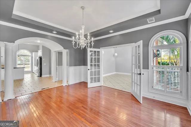 an empty room with windows and ceiling fan