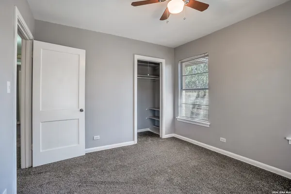 an empty room with chandelier fan