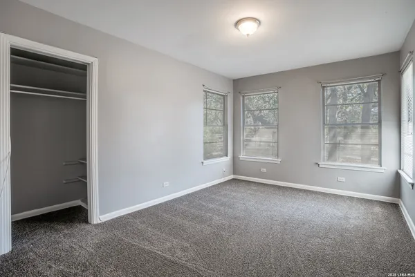 an empty room with windows and closet