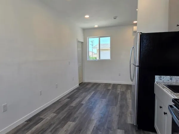 an empty room with wooden floor and a window