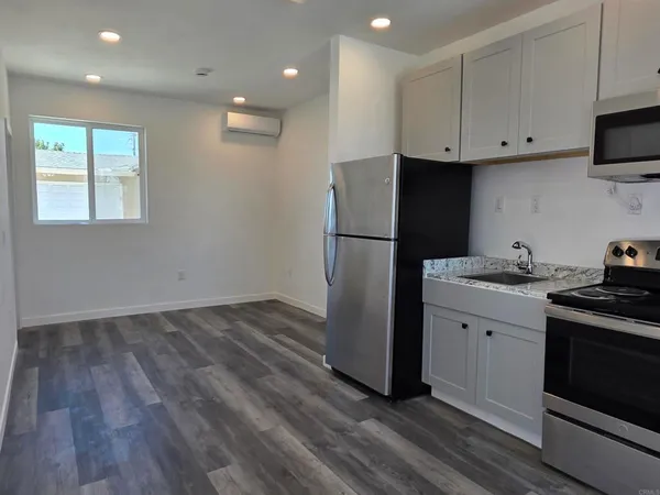 a kitchen with a refrigerator and a stove top oven