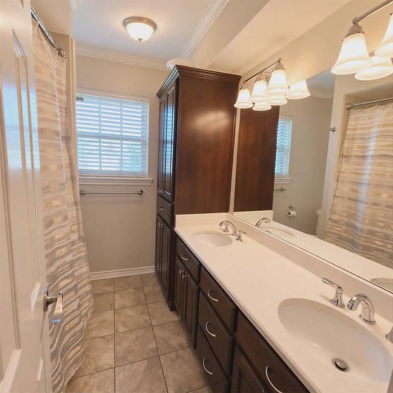 14752 Ranch Road Forney, TX 75126 - Photo 31 of 40 Full second bathroom featuring a double vanity with integrated sinks, dark wood-finish cabinetry, and a full-width mirror-This photo was taken before family moved in