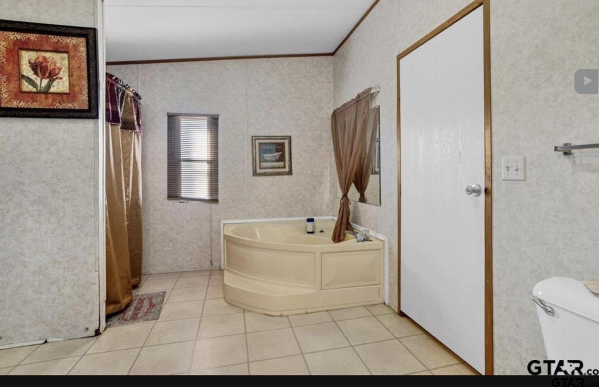 865 County Road Saltillo, TX 75478 - Photo 12 of 22 a bathroom with a sink a mirror and a bathtub