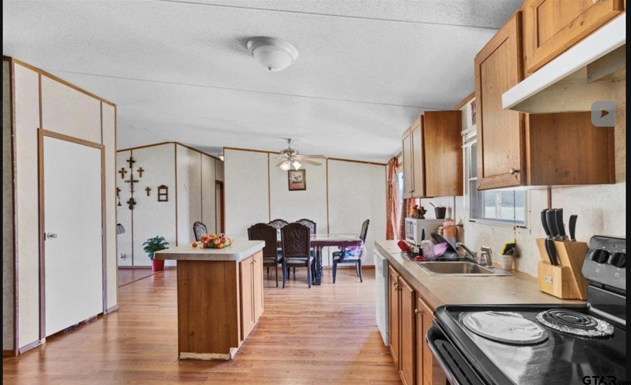865 County Road Saltillo, TX 75478 - Photo 16 of 22 a kitchen with stainless steel appliances granite countertop a stove and a dining table with wooden floor