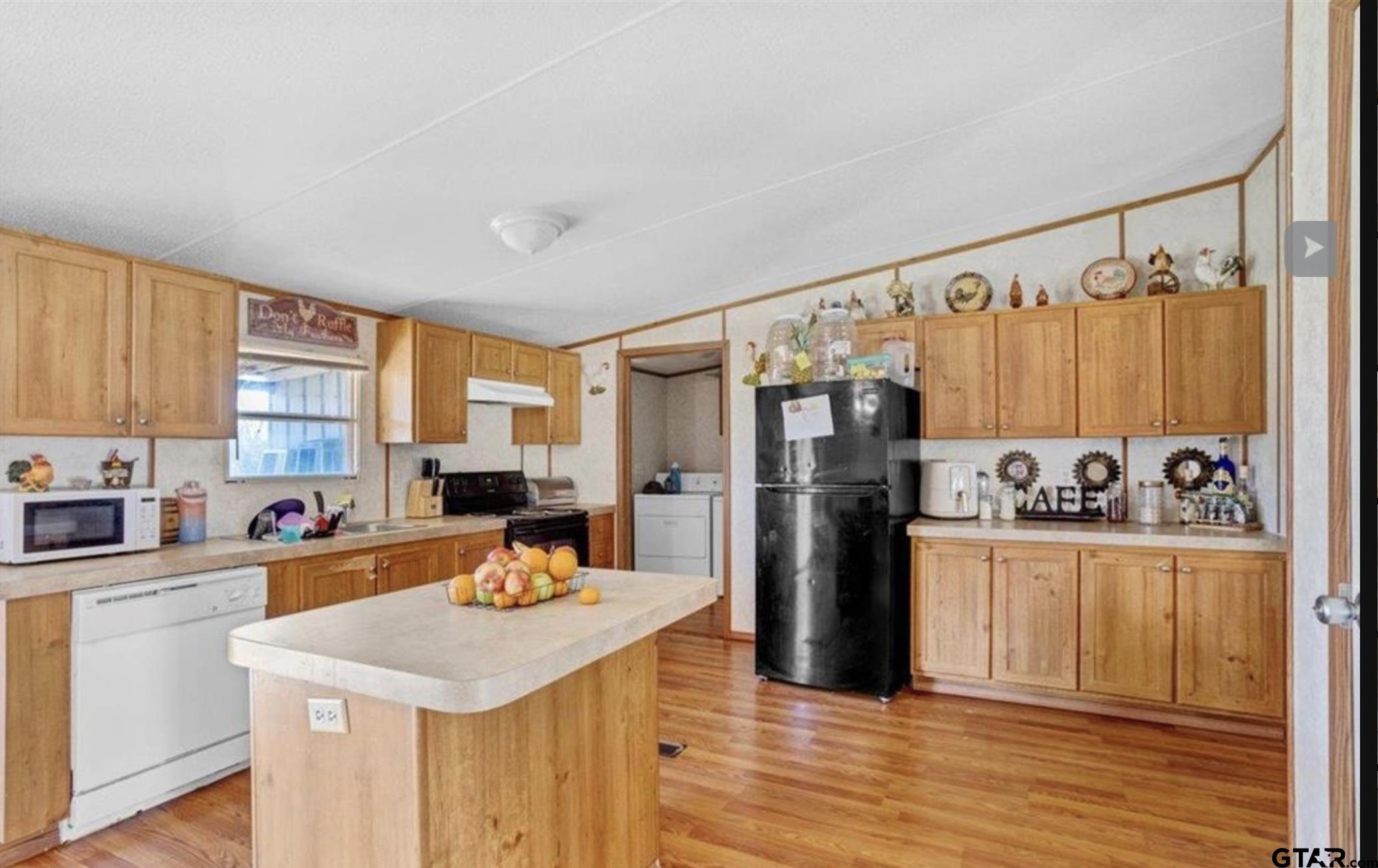865 County Road Saltillo, TX 75478 - Photo 17 of 22 a kitchen with stainless steel appliances a stove a sink dishwasher a refrigerator white cabinets and wooden floor