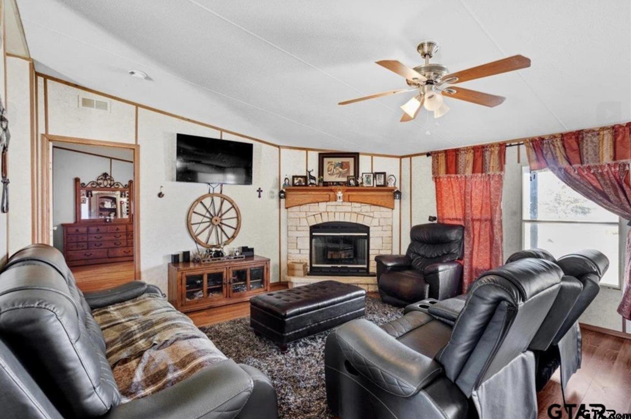 865 County Road Saltillo, TX 75478 - Photo 20 of 22 a living room with furniture a flat screen tv and a fireplace