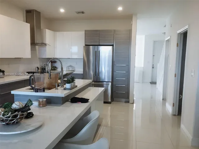 a kitchen with sink refrigerator and cabinets