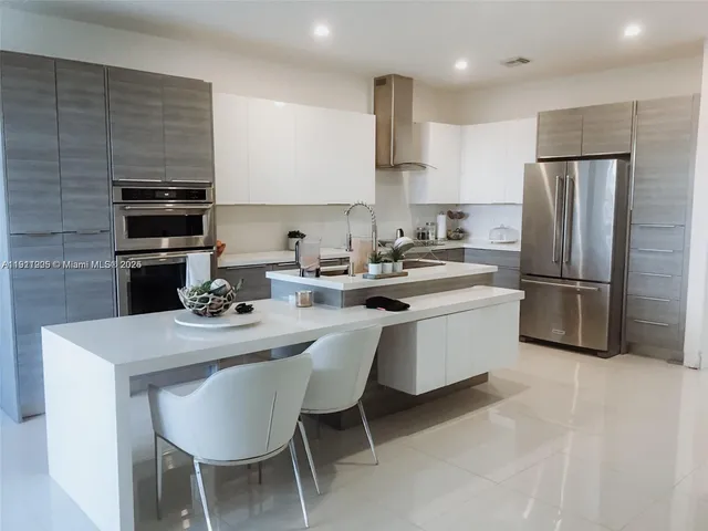 a kitchen with a sink a stove a refrigerator and white cabinets