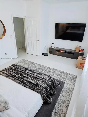 a bedroom with a bed and flat screen tv