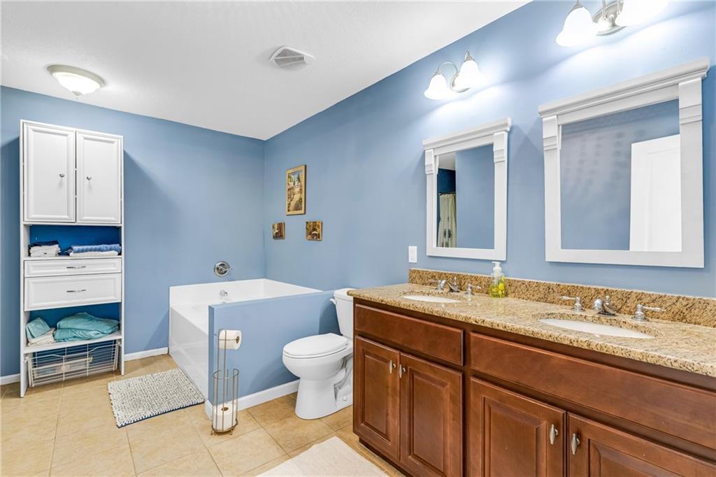 110 Bethel Village Road Eastman, GA 31023 - Photo 23 of 32 a bathroom with a granite countertop toilet a sink and a mirror