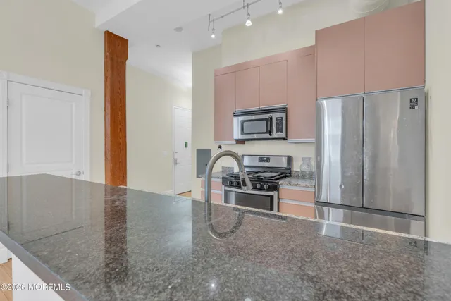 a kitchen with stainless steel appliances granite countertop a refrigerator and a stove