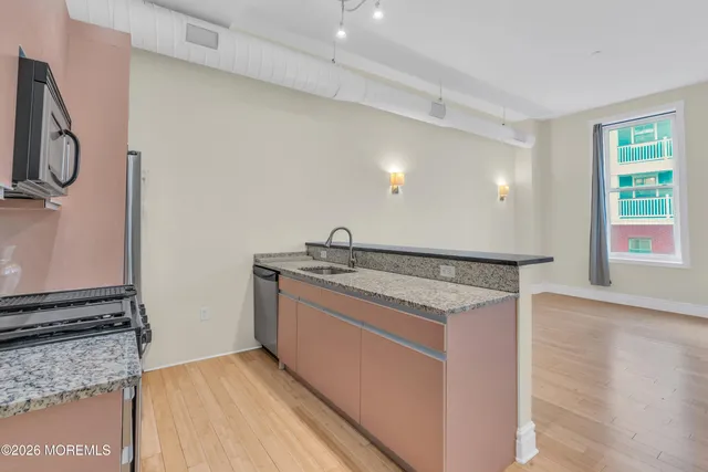 a kitchen with stainless steel appliances granite countertop a sink and a stove