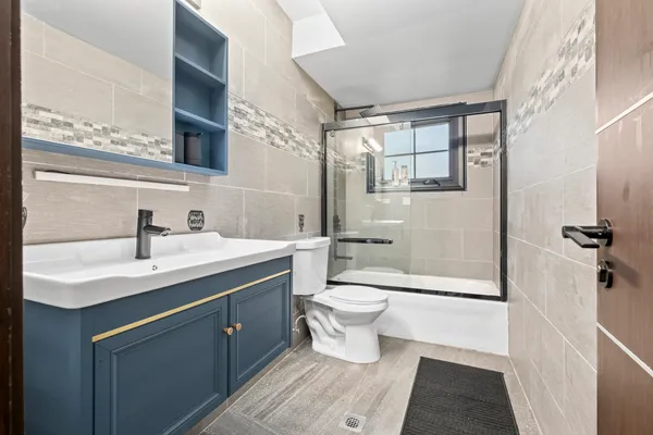 a bathroom with a sink toilet a mirror and shower
