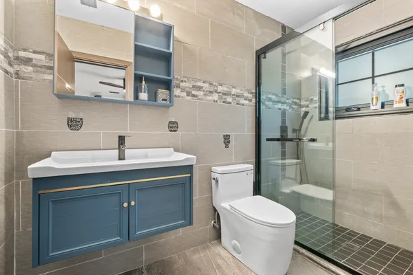 a bathroom with a sink a toilet and shower