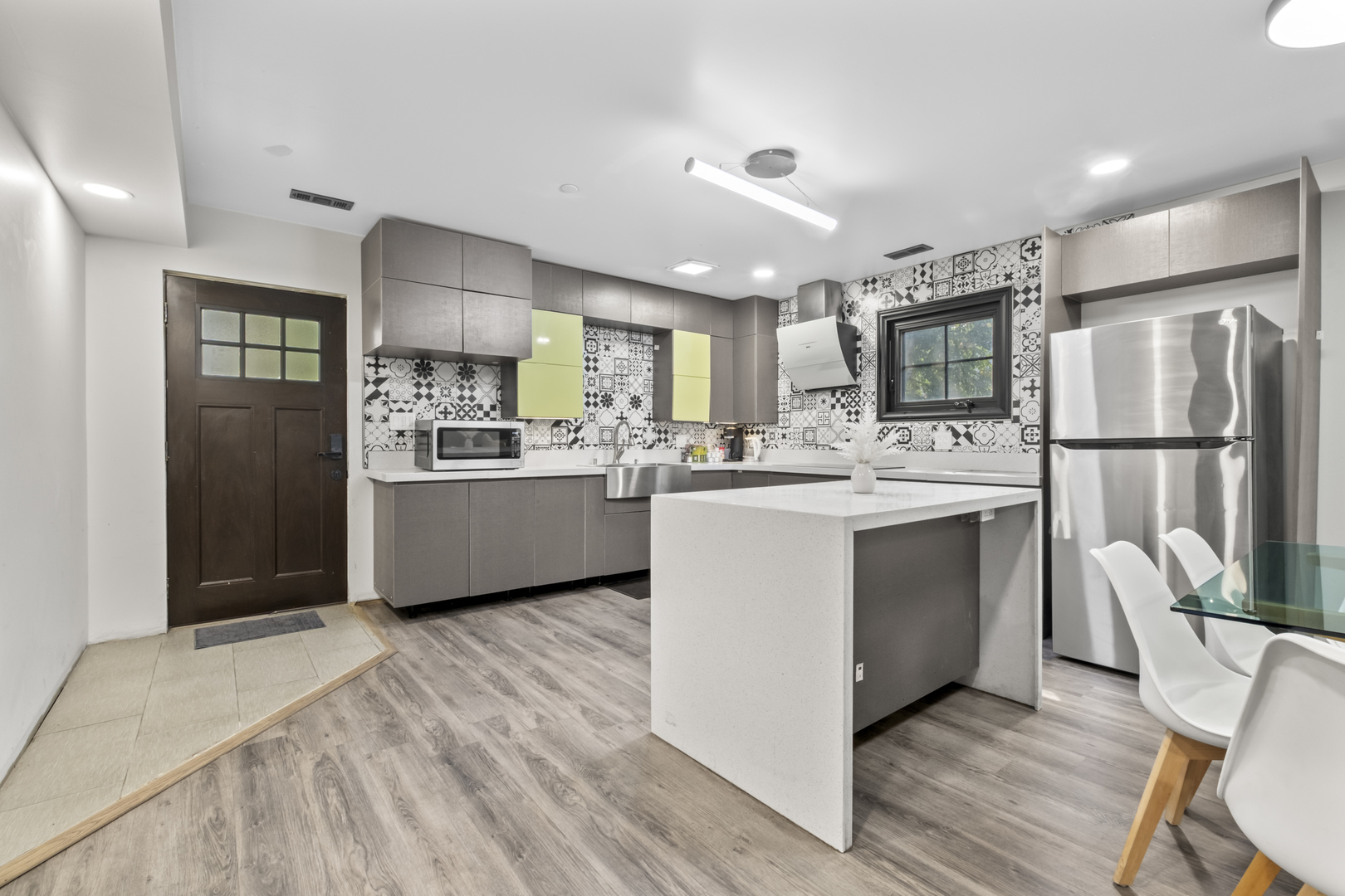 2307 Lake Street, Unit 2 Evanston, IL 60201 - Photo 7 of 20 a kitchen with stainless steel appliances kitchen island granite countertop a refrigerator a sink dishwasher a stove top oven a refrigerator with island and chairs