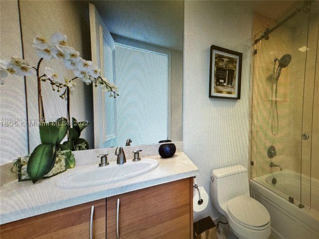 a bathroom with a granite countertop sink a toilet and shower