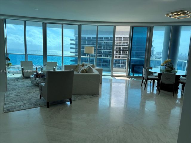 a living room with furniture and large windows