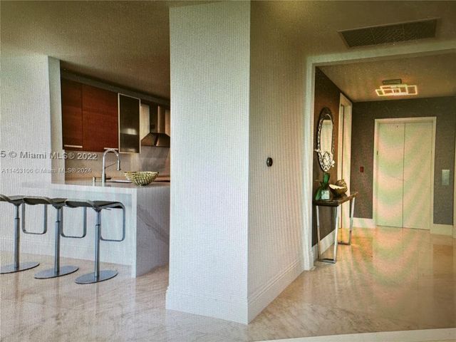 a view of a hallway with wooden floor and a living room