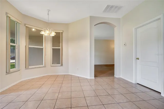 a view of a big room with windows and chandelier