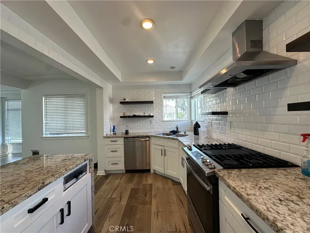 a kitchen with stainless steel appliances granite countertop a stove sink and cabinets