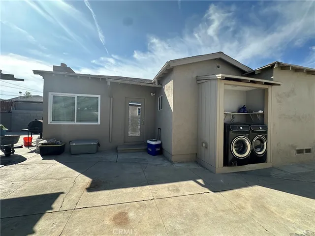 a living room with stainless steel appliances furniture a rug and a window
