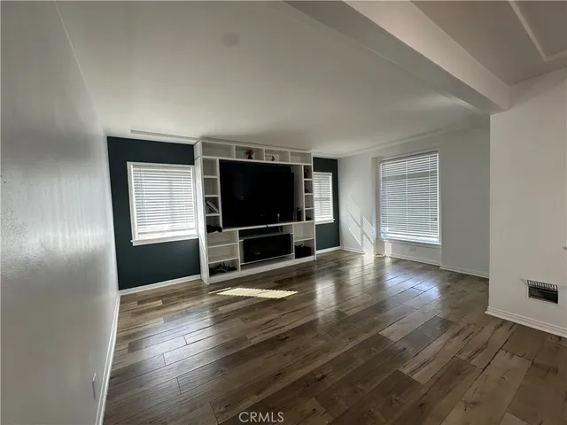 a living room with hardwood floor and a flat screen tv