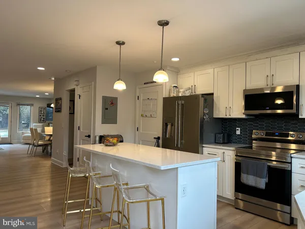 a kitchen with stainless steel appliances kitchen island granite countertop a sink a stove and a refrigerator