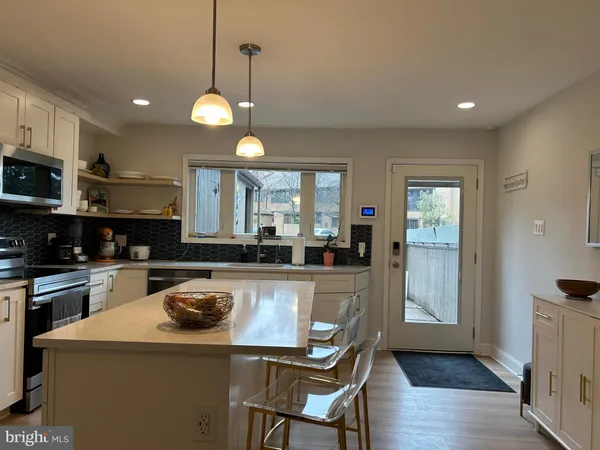 a kitchen with sink a stove and chairs