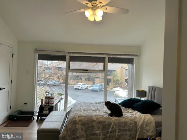 a bedroom with a bed and a large window