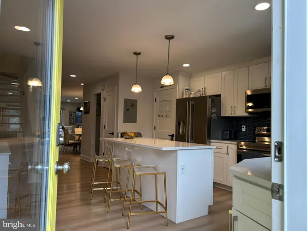 a large kitchen with kitchen island stainless steel appliances a stove a sink and a refrigerator