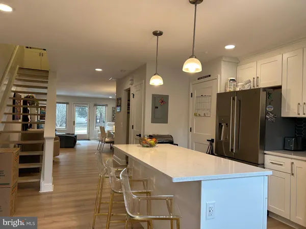 a kitchen with stainless steel appliances kitchen island granite countertop a stove a refrigerator a kitchen island a sink a refrigerator and chairs