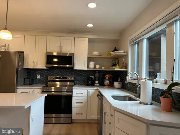 a kitchen with a sink a stove and cabinets