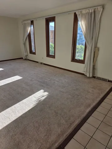 an empty room with windows and mirror