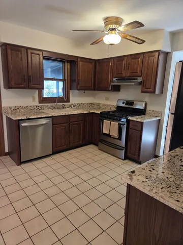 a kitchen with stainless steel appliances granite countertop a stove sink and cabinets