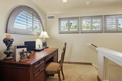 a view of a workspace with furniture and a window