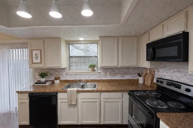 a kitchen with stainless steel appliances granite countertop a sink stove and microwave