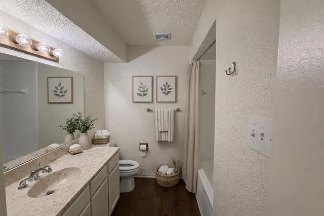 a bathroom with a granite countertop sink toilet and shower