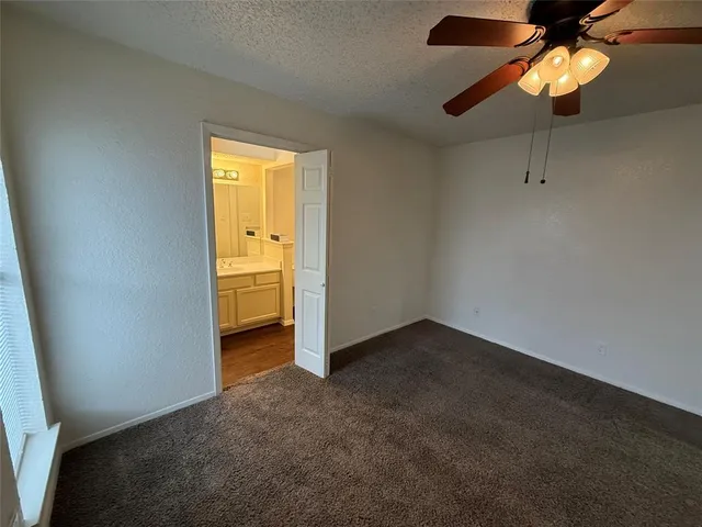 an empty room with a fan & a window