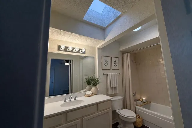 a bathroom with a sink a toilet a mirror and shower