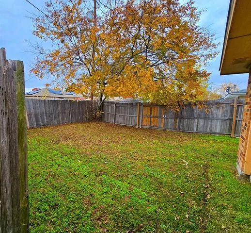 a view of a backyard with a small pool and wooden fence