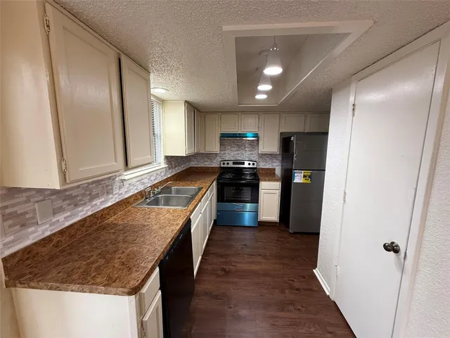 a kitchen with stainless steel appliances granite countertop refrigerator a sink and wooden cabinets