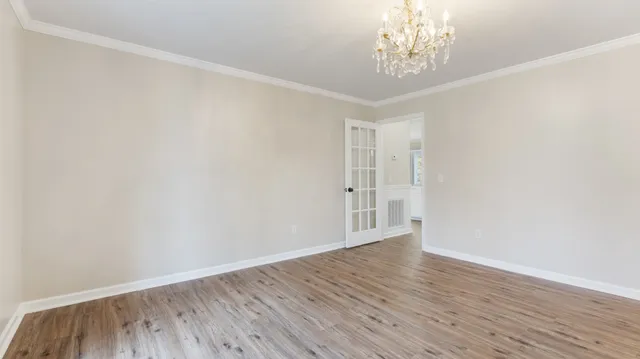 a kitchen with stainless steel appliances granite countertop a stove a sink dishwasher a refrigerator and white cabinets with wooden floor