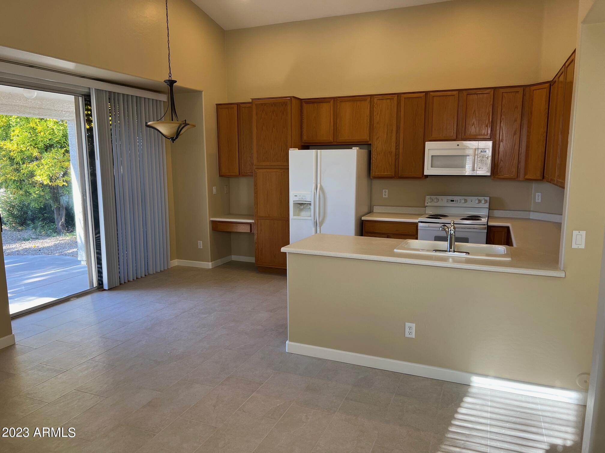 924 South Roanoke Street Gilbert, AZ 85296 - Photo 3 of 6 a kitchen with a refrigerator and a sink