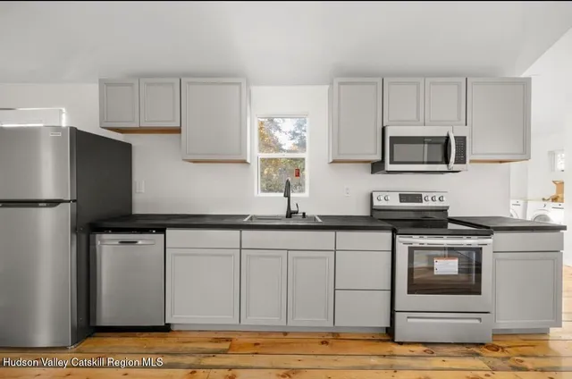 a kitchen with stainless steel appliances granite countertop a stove a sink and a microwave