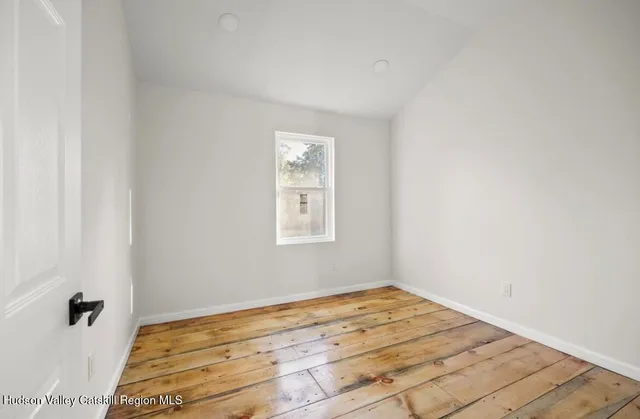 a view of a room with wooden floor and white walls